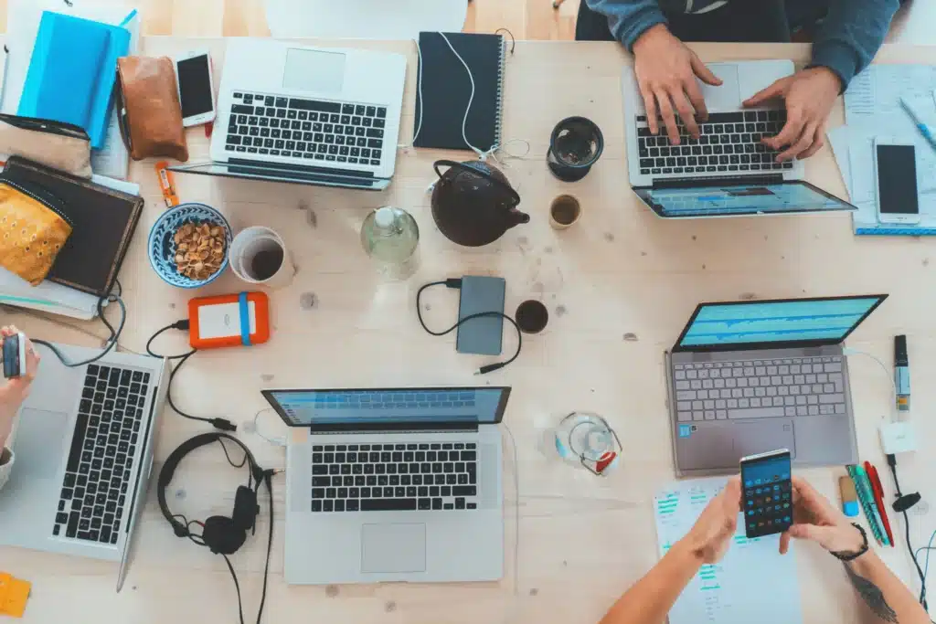 A team of professionals working together on laptops at a table, showcasing teamwork in a contemporary office setting.